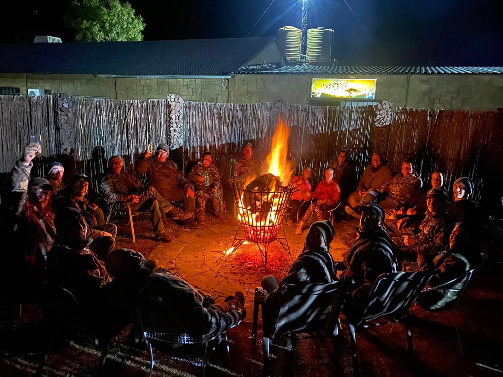 Guests of all ages around the campfire after a day in the field